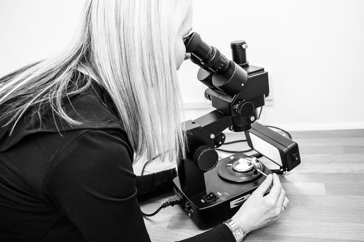 Our Expert valuer examining gemstones under a microscope