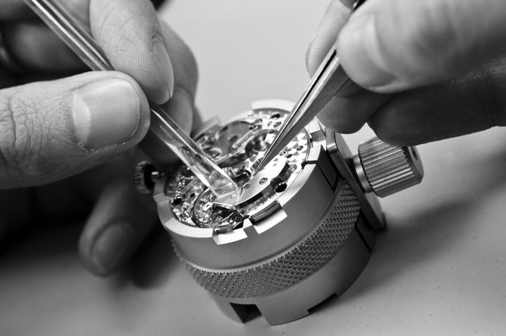 Watch movement being repaired delicately