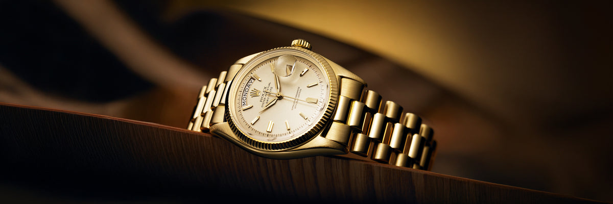 Rolex Day-Date gold wristwatch with a dark background