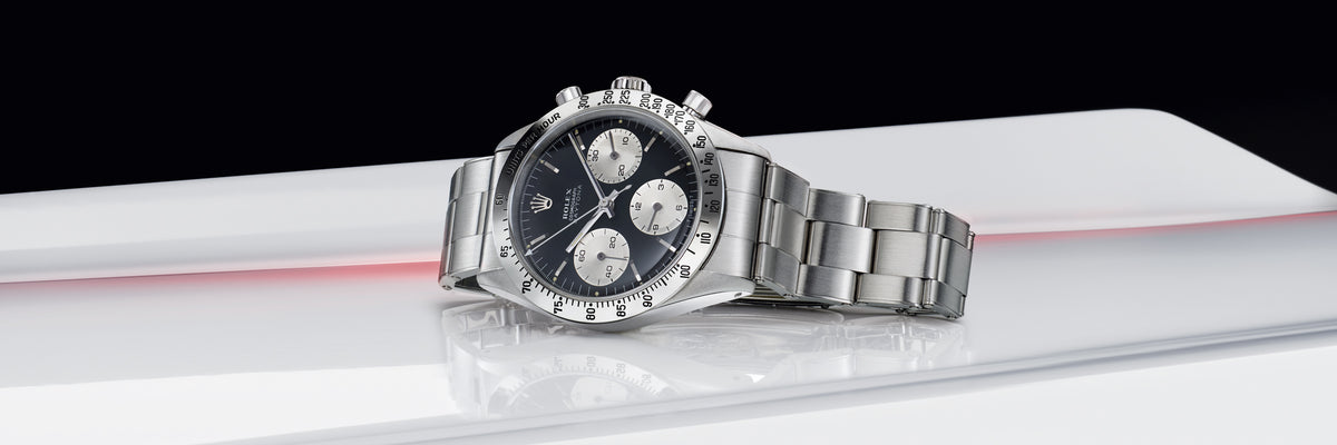 Rolex Cosmograph Daytona watch with black face on a white platform