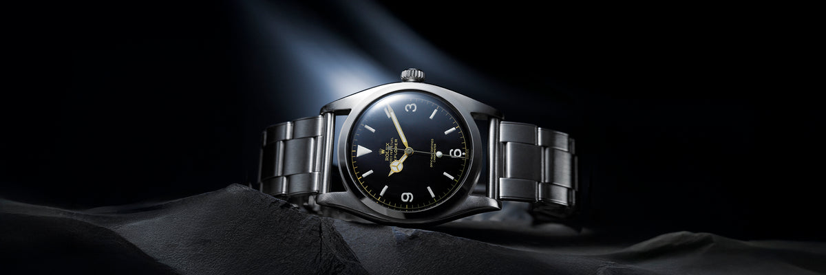 Rolex Explorer watch with black face on a dark background
