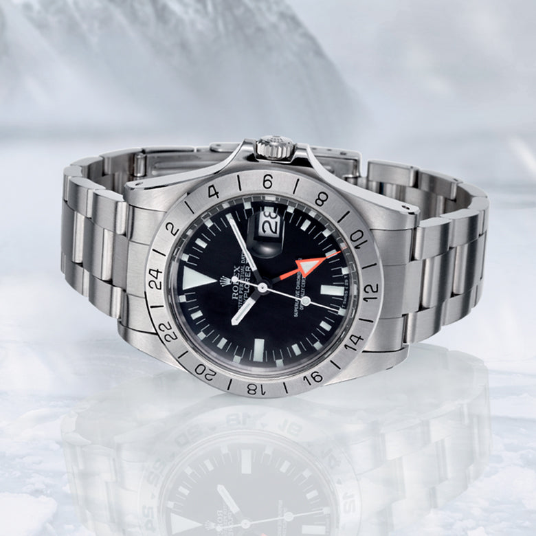 Rolex Explorer II watch with black dial on a reflective white surface