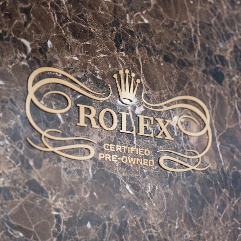 Rolex Certified Pre-Owned logo on a marble surface
