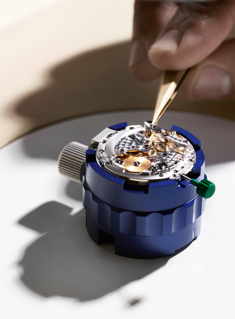 Watchmaker adjusting a watch mechanism on a white background