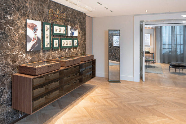 Modern interior with wooden display cases against a marble wall.