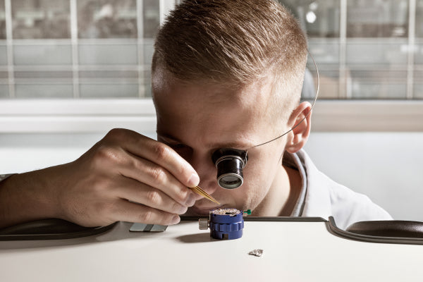 Rolex watchmaker examining a movement
