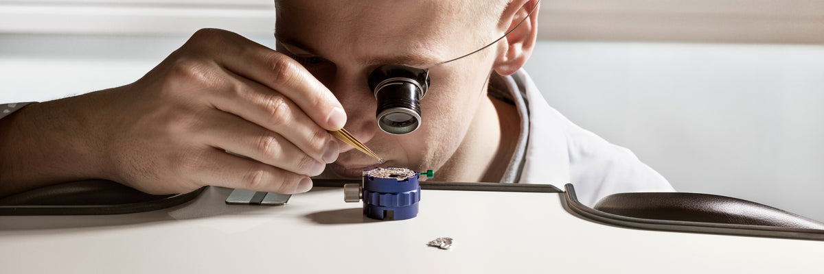 Rolex watchmaker examining a movement