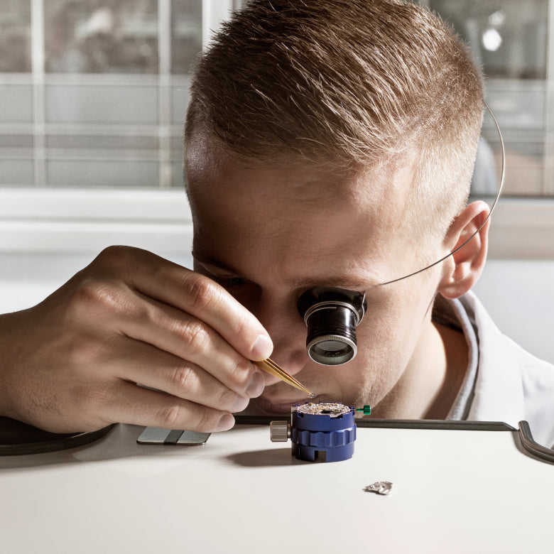Rolex watchmaker examining a movement